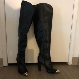 Black over the knee boots with gold tone details.
